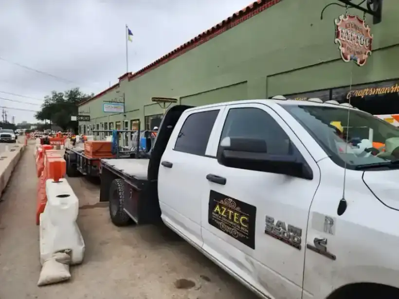 The Aztec Fence and Ornamental Iron RAM 3500 flatbed truck with the company magnet on a street job